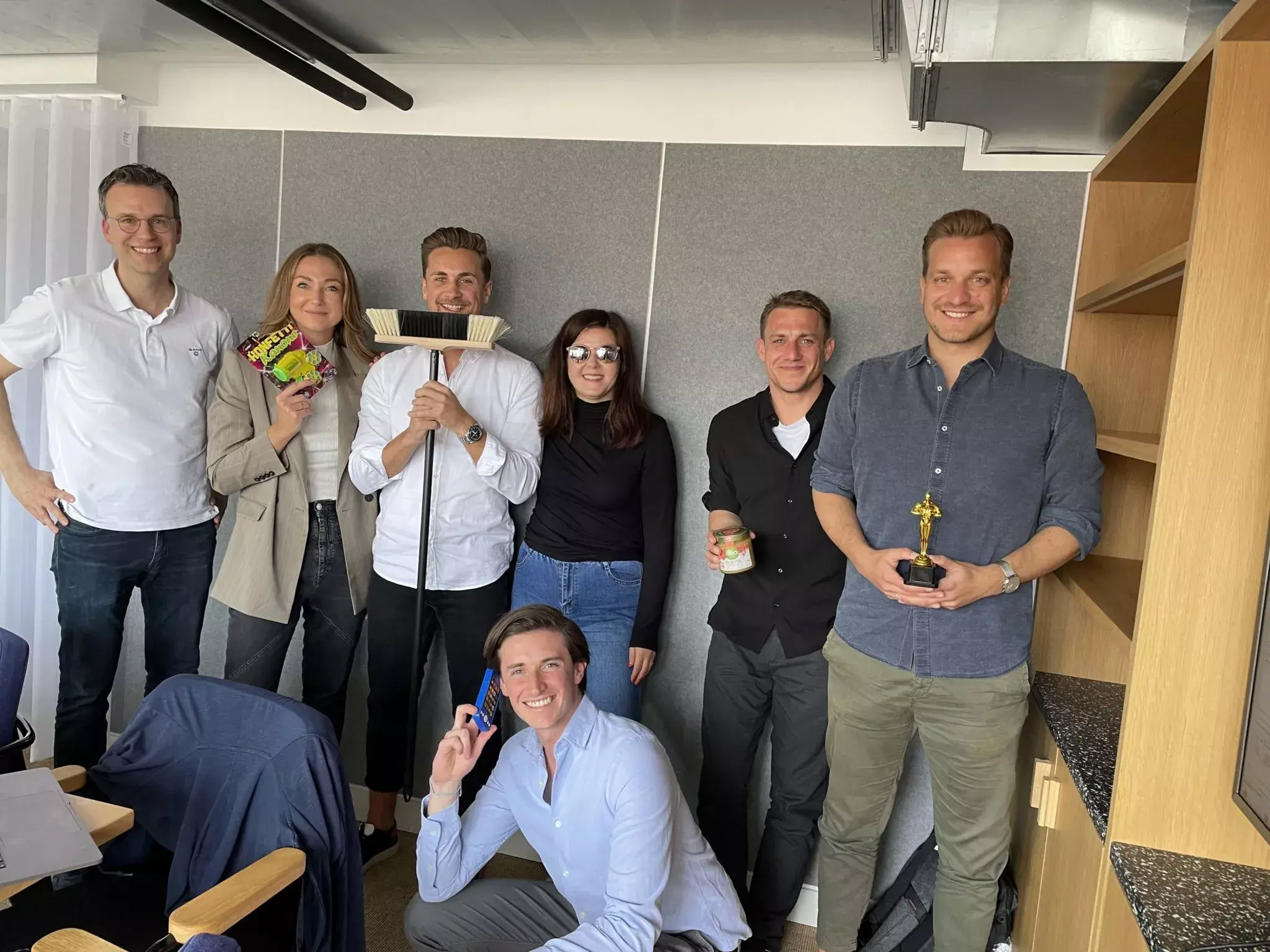 Steinke (holding the broom), shares a light moment with his Asana colleagues in the Munich office.