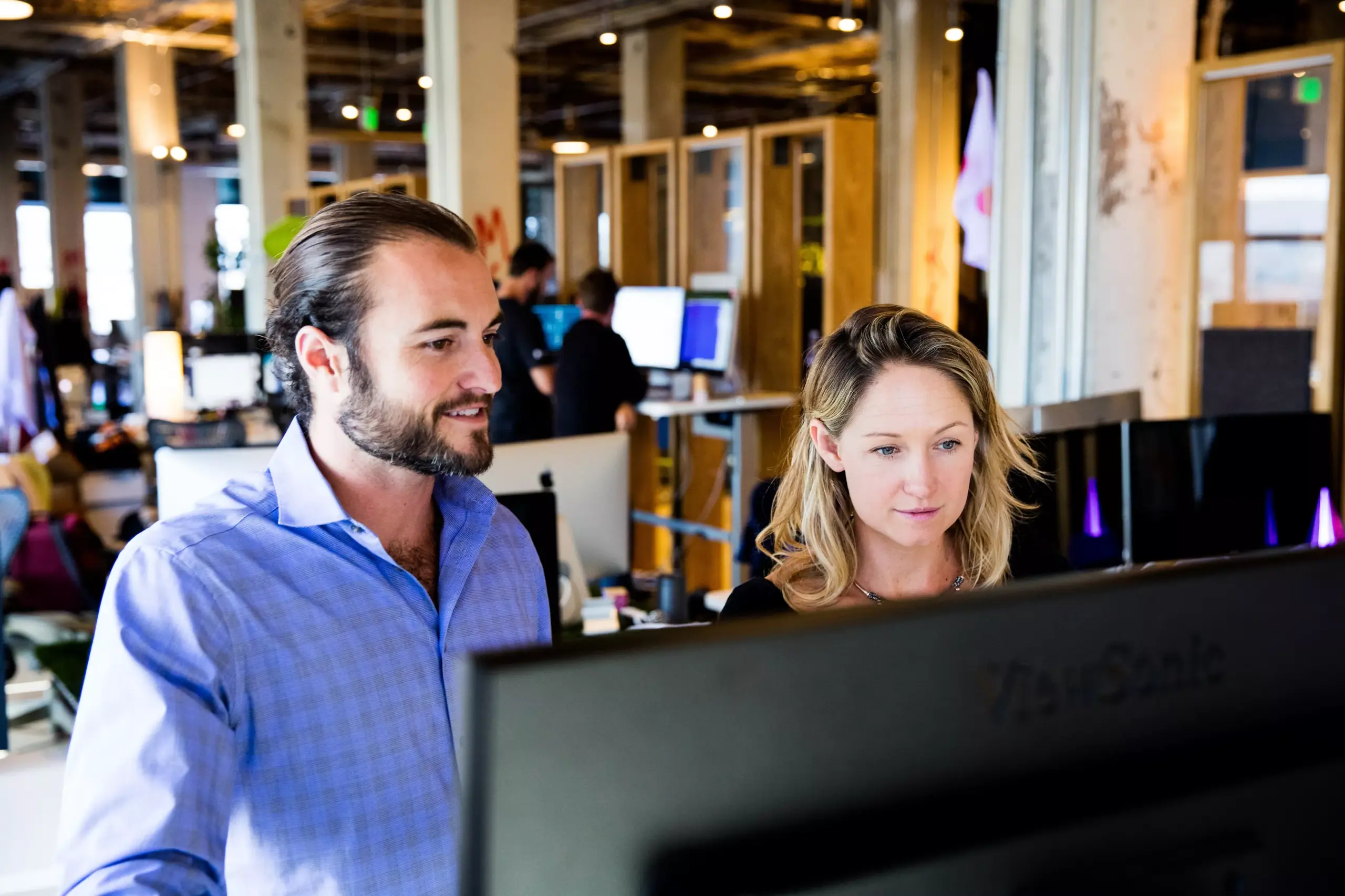 Two people looking at a computer in an office